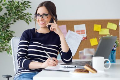 Young female REALTOR having a positive phone conversation with a client