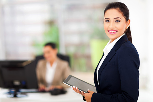 Woman REALTOR holding an iPad and turning to smile at the camera