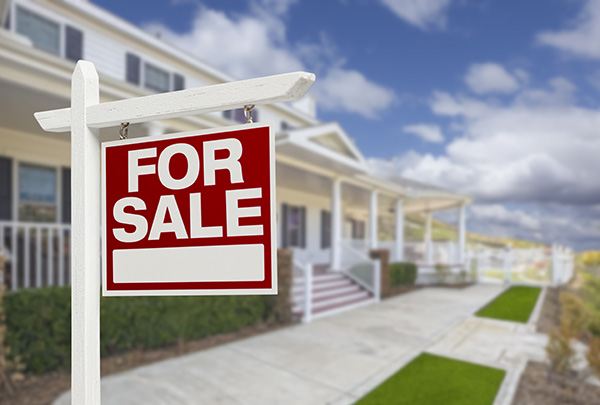 For Sale sign posted in front of a house with stairs leading to a wraparound porch