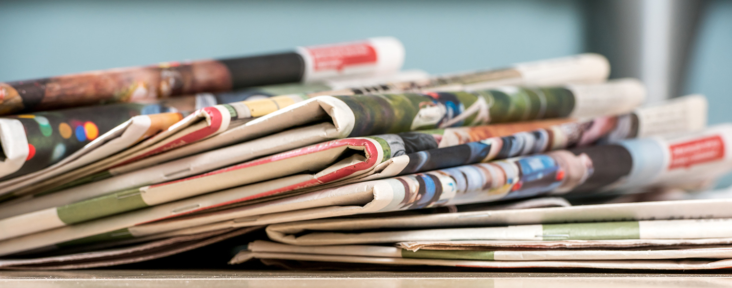 stack of old newspapers on a washed wood table