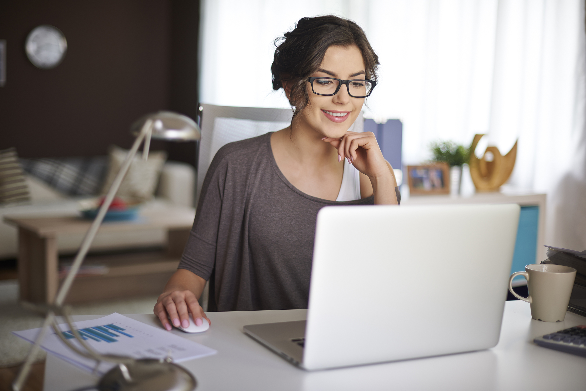 Real estate agent using her business writing skills while working at a laptop